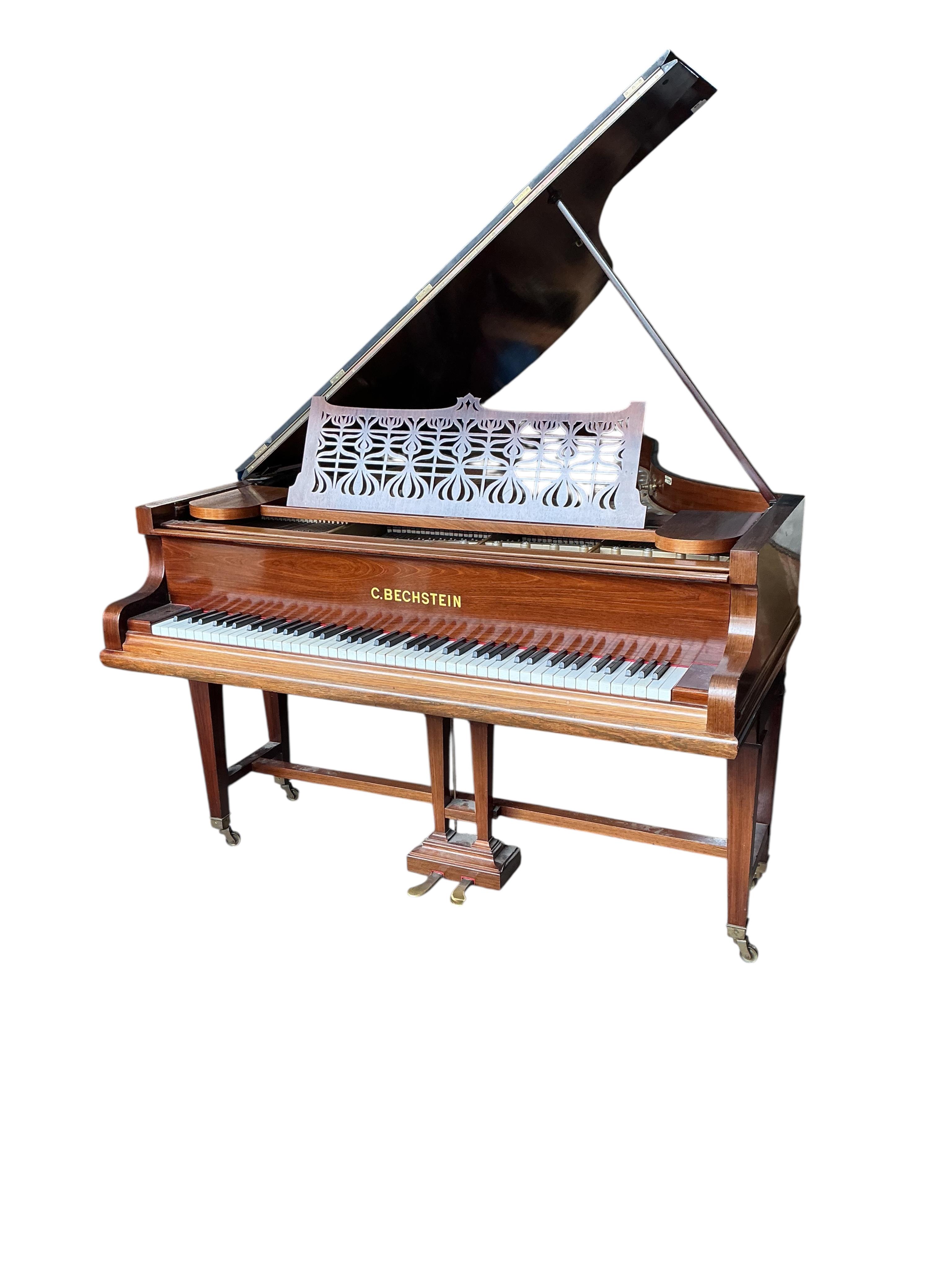 An early 20th century Bechstein 6ft. 8in. rosewood grand piano retailed by Harrods and duet piano stool